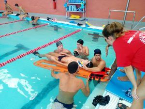 Alumnos del PFAE durante prácticas de primeros auxilios en la piscina cubierta.