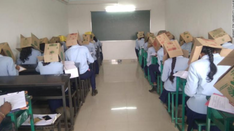Polémica: un grupo de estudiantes realiza un exámen con cajas de cartón en las cabeza para impedir que copien