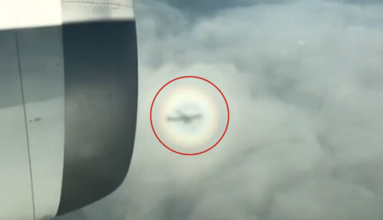 Graban a un avión volando en el interior de un arco iris