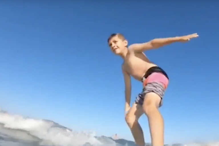 Un tiburón tira a un niño de su tabla mientras practica surf en el mar