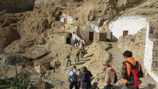 Un grupo de personas transita por el poblado troglodita de Acusa.
