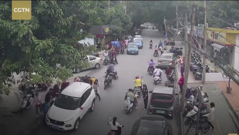 Decenas de peatones aúnan esfuerzos para liberar a una motorista atropellada por un coche