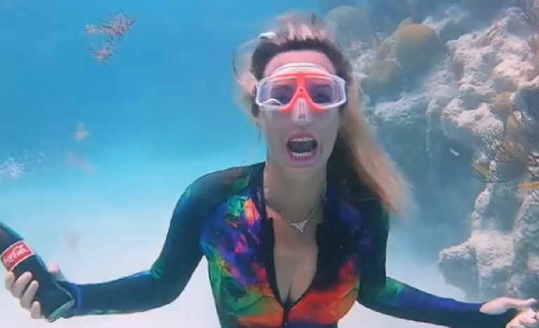 Una mujer abre una botella de Coca Cola en el fondo del océano y esto es lo que sucede