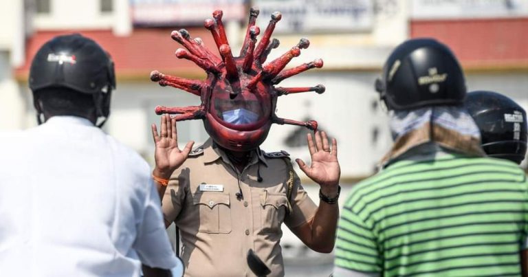 Un policía utiliza un 'casco-coronavirus' para alertar a la población sobre la pandemia