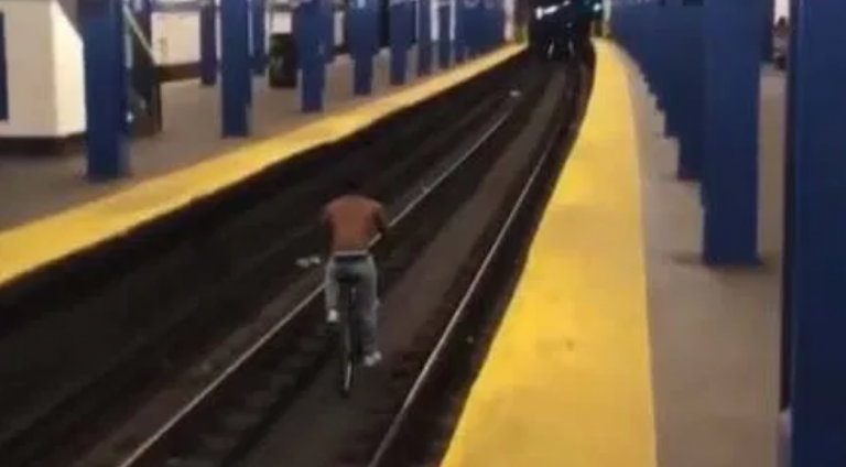Graban a un hombre montando en bicicleta por los raíles del metro de Nueva York