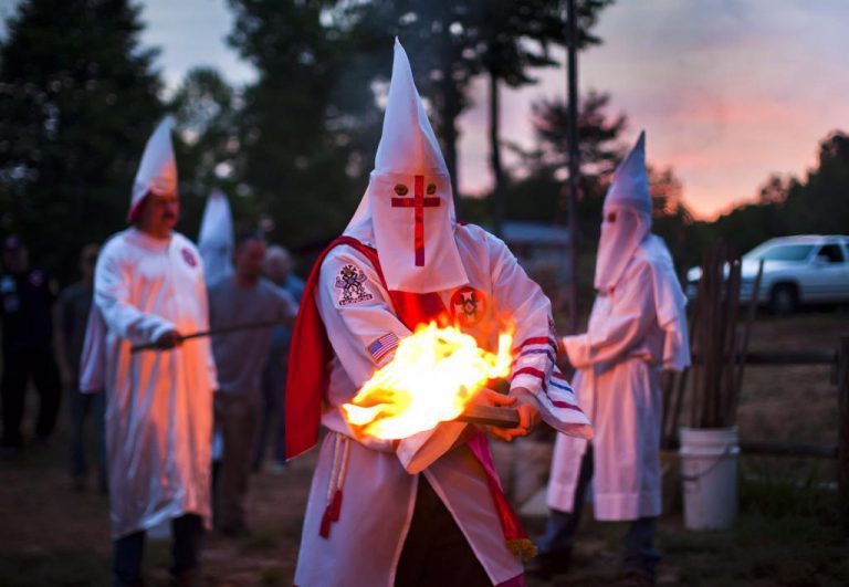 Un hombre hace la compra con una capucha del Ku Klux Klan para protegerse del coronavirus