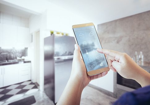 Unknown woman hand using remote home control system on phone.