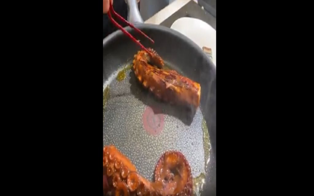 Las patas de pulpo siendo freidas en una sartén. Esta es uno de los pasos para la preparación de este plato.