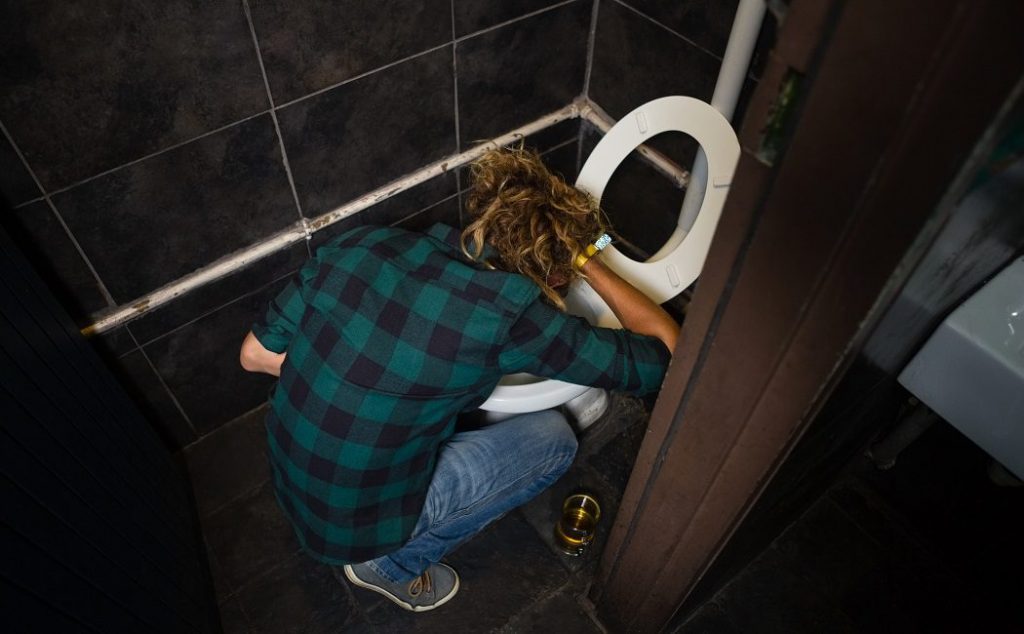 Persona vomitando por alcohol