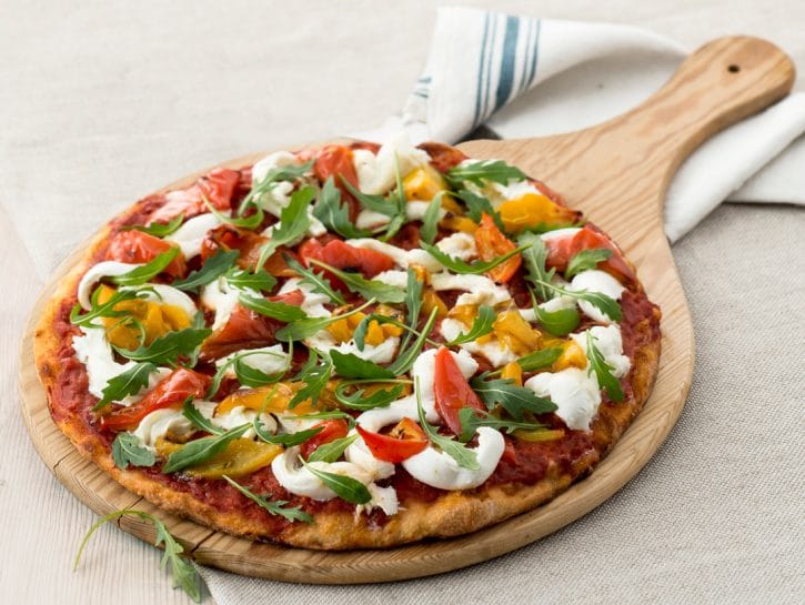 La textura de las verduras en las pizzas puede cambiar.