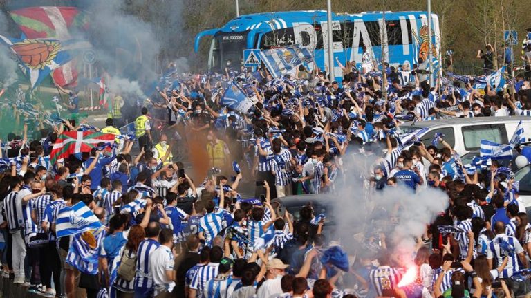 Miles de aficionados despiden a la Real Sociedad en su salida hacia Sevilla sin respetar distancias