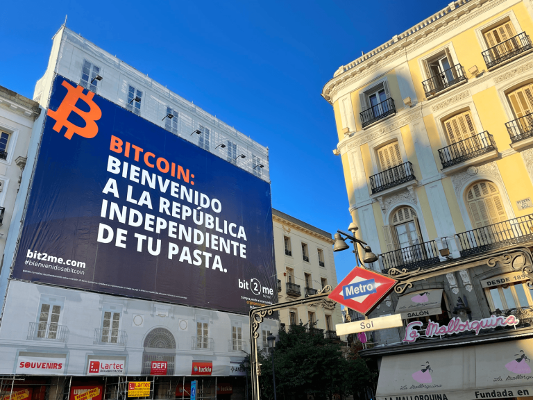 Bit2Me conquista la Puerta del Sol con una lona gigante con un mensaje que no pasa desapercibido