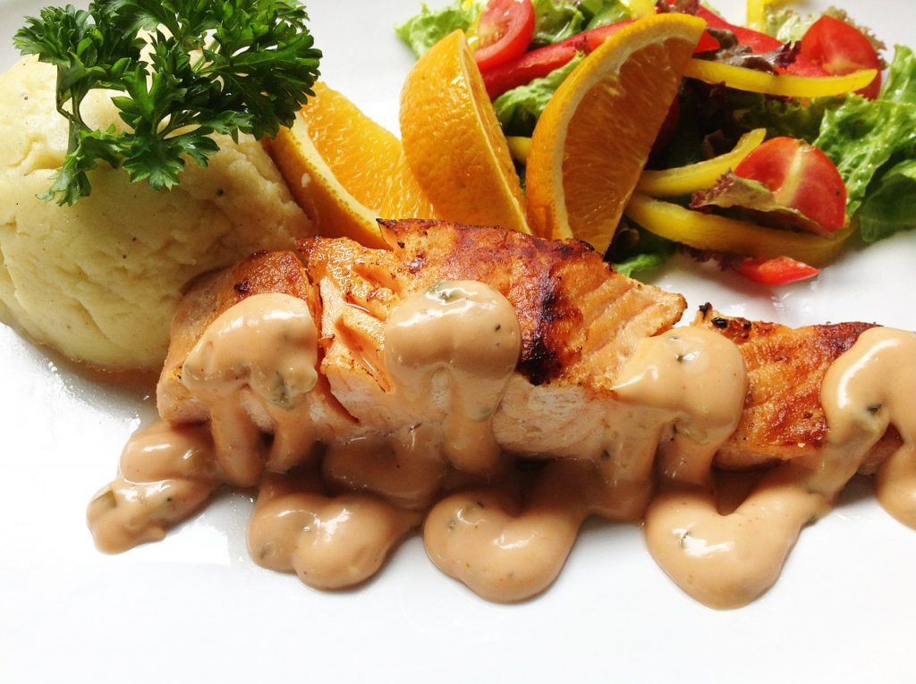 Cuando de salsas versátiles se trata, podemos mencionar por su puesto a la mayonesa y el ketchup como algunas de ellas. Ahora bien, cuando ambas se juntan, solo puede pasar una cosa, y esa es, la perfección. No hay sabor que iguale al de unas frescas gambas con esta salsa rosa, la cual es tan sabrosa, que combina también con las más ricas ensaladas de fruta. Para Arguiñano, una salsa rosa perfecta es el resultado de la mezcla armoniosa de algunos ingredientes y por supuesto, contó todo para que quede realmente deliciosa. Conoce los ingredientes que según el carismático chef, lleva esta tradicional salsa y anímate a disfrutarla. La salsa rosa, digna de un Nobel: este es su origen Son muchos los orígenes que se le atribuyen a la salsa rosa y esto se debe a que por la mezcla de ingredientes con la que se prepara, son muchas las variaciones que han surgido. Ahora bien, todo indica que esta salsa tal como la conocemos en la actualidad, nació de la mano de Luis Federico Leloir, un reconocido científico que de hecho, llegó a ganar un premio Nobel en química gracias a sus investigaciones. Este francés que se trasladó a Argentina a temprana edad y durante un paseo con amigos, mezcló ketchup con mayonesa para acompañar unos langostinos, y de allí nació la popularmente conocida salsa rosa. En 1970, Leloir afirmó: "Si hubiese patentado la salsa rosa, ganaría mucho más dinero que como científico". Entre salsas, nombres y orígenes Aunque este Nobel inventó este aderezo, ya en Estados Unidos existía uno muy parecido, la salsa 'thousand island dressing', la cual, también se prepara con los dos mismos ingredientes principales, y le es añadida una cierta cantidad de verduras encurtidas picadas. Lo cierto es que fue la versión del químico la que llegó a España, y allí nació su nombre final “salsa rosa”, que también se conoce en Latinoamérica bajo diversos nombres, como: ‘mayocachú’ en República Dominicana, ‘mayoketchup’ en Puerto Rico y ‘salsa rosada’ en Venezuela. La versión que presenta Arguiñano, es adaptada a la original, así que será de lo más auténtica. Estos son los ingredientes de la original Cuando a mediados de 1920, Luis Federico Leloir, asistió al Golf Club en compañía de sus amigos, se encontraba algo cansado de comer los camarones con una simple mayonesa; es por esta razón que solicitó que se le llevara a la mesa otros ingredientes, entre los que le llevaron: limón, vinagre, mostaza, ketchup y especias. Con una mayor proporción de mayonesa, un poco de ketchup, limón y mostaza, la salsa resultó perfecta. Entre industrial y casera, la casera está mejor Si vas al supermercado y buscas una salsa rosa, seguramente podrás observar que existe una gran variedad de marcas y presentaciones; y sí, aunque muchas de ellas se pueden considerar de buen sabor, nada como prepararla en casa. En esta propuesta de Karlos Arguiñano, podrás comprobar por ti mismo lo fácil que es hacer esta salsa en casa. Su sabor te sorprenderá, y sus ingredientes, son de lo más sencillos. La propuesta de Arguiñano para alegrar cualquier plato Si bien, la salsa rosa combina divinamente con unos camarones o langostinos frescos, también es común encontrarla acompañando otro tipo de proteínas, como pollo, filetes y pescados. Por su sabor algo atrevido, es perfecta para servir junto a unas crujientes patatas gajo y comerlas mientras se disfrutan unas buenas cervezas frías. Estos son los ingredientes que utiliza Arguiñano para hacer la más exquisita salsa rosa La propuesta que ha presentado Karlos Arguiñano, se adapta perfectamente a la más auténtica salsa rosa; y así, como hace muchos años, se fuisonaron de manera perfecta unos pocos ingredientes, de la misma manera, este chef ha logrado sorprender con este delicado resultado. Necesitarás para la mayonesa casera: 1 huevo, aceite, sal, limón. Para la salsa rosa: mayonesa, 2 cucharadas de zumo de naranja, 3 cucharadas de ketchup, ½ cucharadita de salsa picante (puede ser tabasco), 1 cucharadita de salsa inglesa y 1 cucharada de whisky. Comienza por la preparación de la mayonesa casera al estilo de Arguiñano Hacer la mayonesa casera al estilo de Arguiñano, no tiene ninguna complicación. Solamente necesitas tener a la mano los ingredientes y un batidor. Pon en el batidor el huevo, unas gotas de limón o naranja, sal y comienza a batir sin subir el brazo batidor. Comienza a añadir el aceite en forma de hilo fino y a medida que observes que comienza a emulsionar, sube un poco el brazo. Continúa añadiendo aceite hasta formar una crema suave. Cuida las proporciones para una salsa rosa perfecta Aunque se desconocen las proporciones exactas que utilizo Leloir, para hacer la salsa rosa, las proporciones que sugiere Arguiñano te permitirán disfrutar de un toque de sabor perfecto. Por supuesto, hay ingredientes de los que puedes obviar su uso o aumentar su cantidad según tu gusto. No obstante, trata de que no se te vaya la mano en alguno de ellos, pues cambiará por completo el resultado final. Así se prepara esta rica salsa rosa Para prepararla, deja la mayonesa casera que preparaste dentro del batidor. Añade la salsa ketchup, y el resto de los ingredientes y procede a remover todo muy bien hasta integrarla por completo. El resultado debe ser una salsa de color rosa suave y de consistencia cremosa, pero a la vez sedosa, que pueda bañar el plato en el que la vayas a disfrutar con total elegancia. Forma de servirla Tal como te he comentado, esta salsa suele disfrutarse acompañando mariscos como los camarones, gambas y langostinos. Sin embargo, puedes añadirla a los platillos de tu elección. Lo que te puedo garantizar, es que será divina acompañando un rico coctel de langostinos en la noche de Navidad.