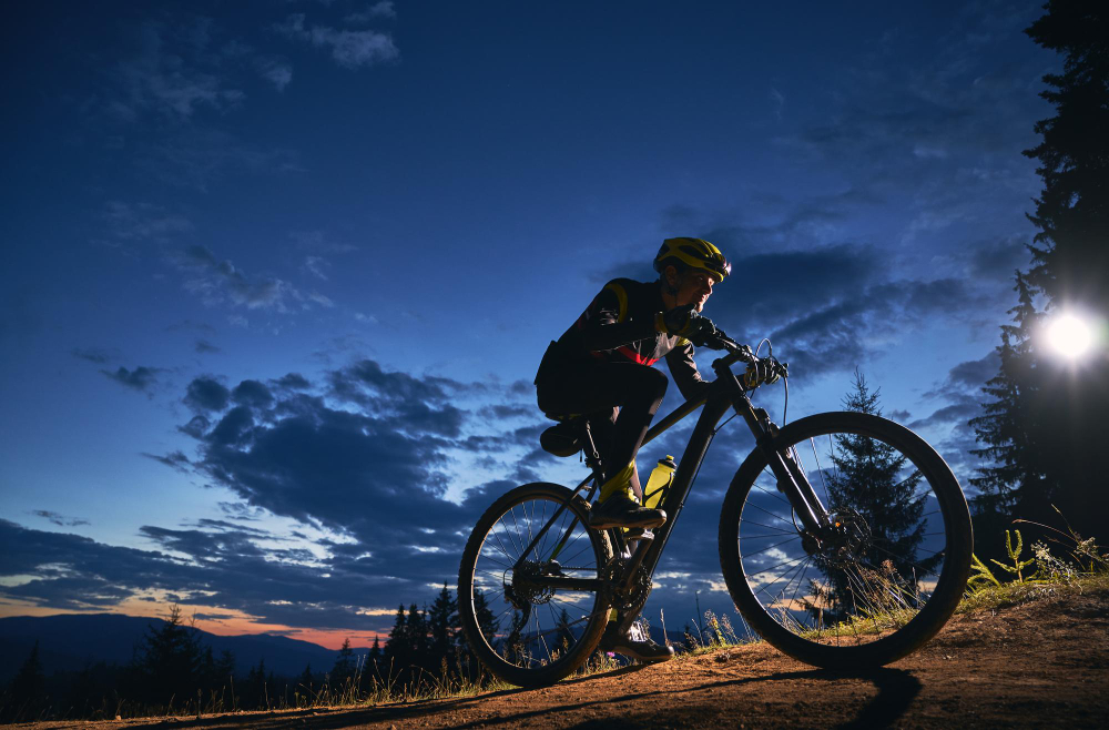 cyclist sitting on bicycle under cloudy night sky