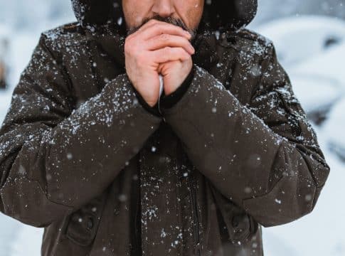 Portrait of the caucasian man in a hat on the street in winter.