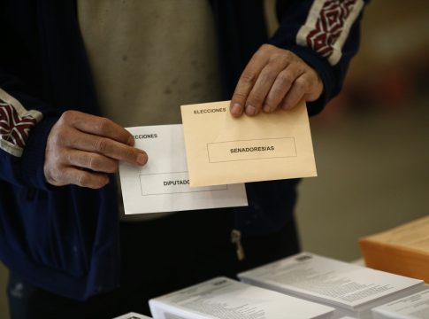 - Un elector sostiene sus sobres de votación para las generales.
