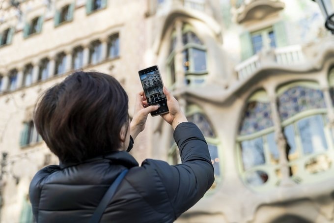 Una turista realiza una fotografía con su teléfono móvil a la Casa Batlló de Barcelona 