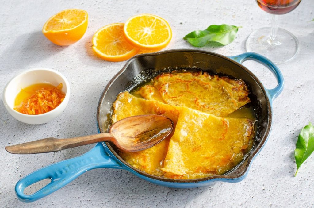 Descubre el encanto de las crepes 'Suzette' con supremas de Naranja: un viaje gastronómico con sabor a tradición francesa 2 crepes suzette macerando en la salsa