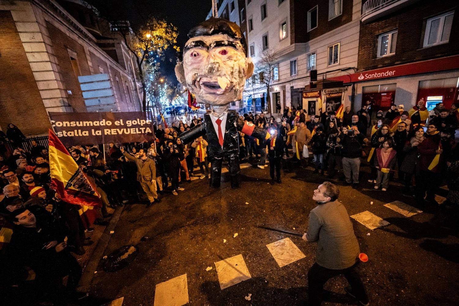 Decenas de personas celebran la entrada del año nuevo en la calle Ferraz, a 1 de enero de 2024, en Madrid (España). Revuelta, la organización juvenil de la órbita de Vox convocante de las concentraciones en Ferraz, ha llamado a tomar las uvas esta Nochevieja frente a la sede federal del PSOE,