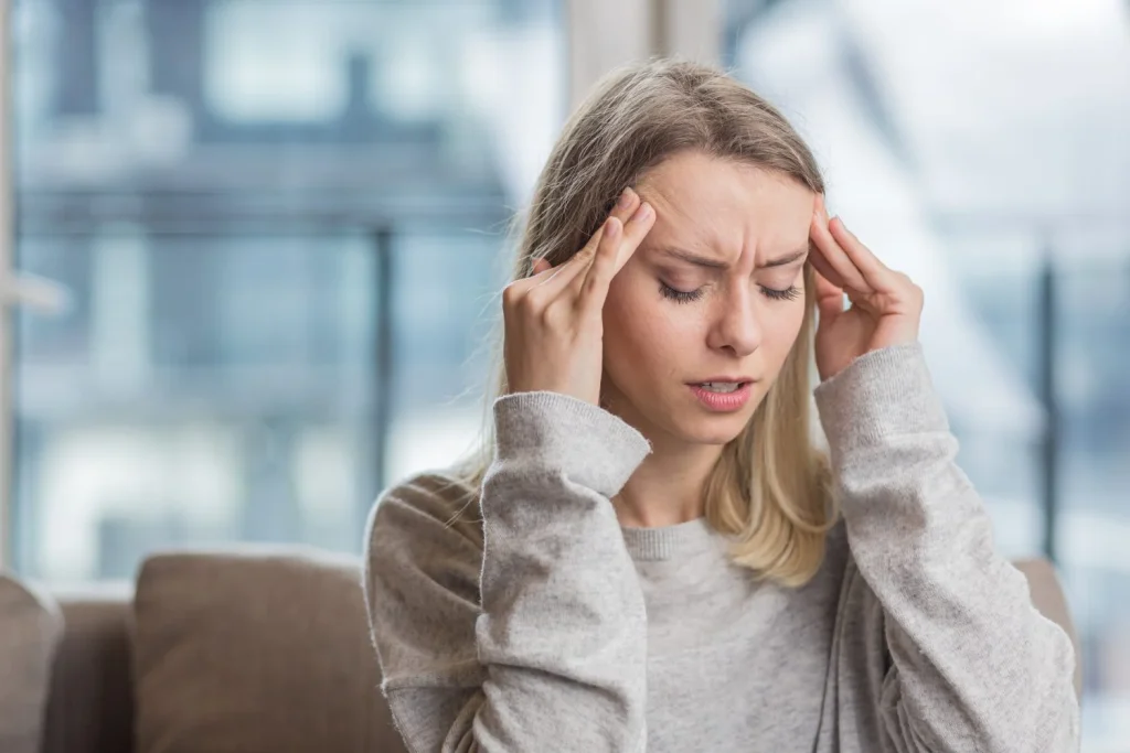 woman holding her head anxious about unbearable headache