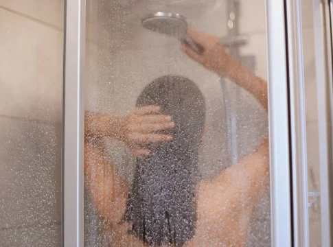 disfrutando-de-una-ducha-vista-posterior-de-la-hermosa-joven-delgada-sin-camisa-tomando-ducha-lavarse-el-cabello-en-el-bano-higiene-salud-y-belleza-tiro-interior