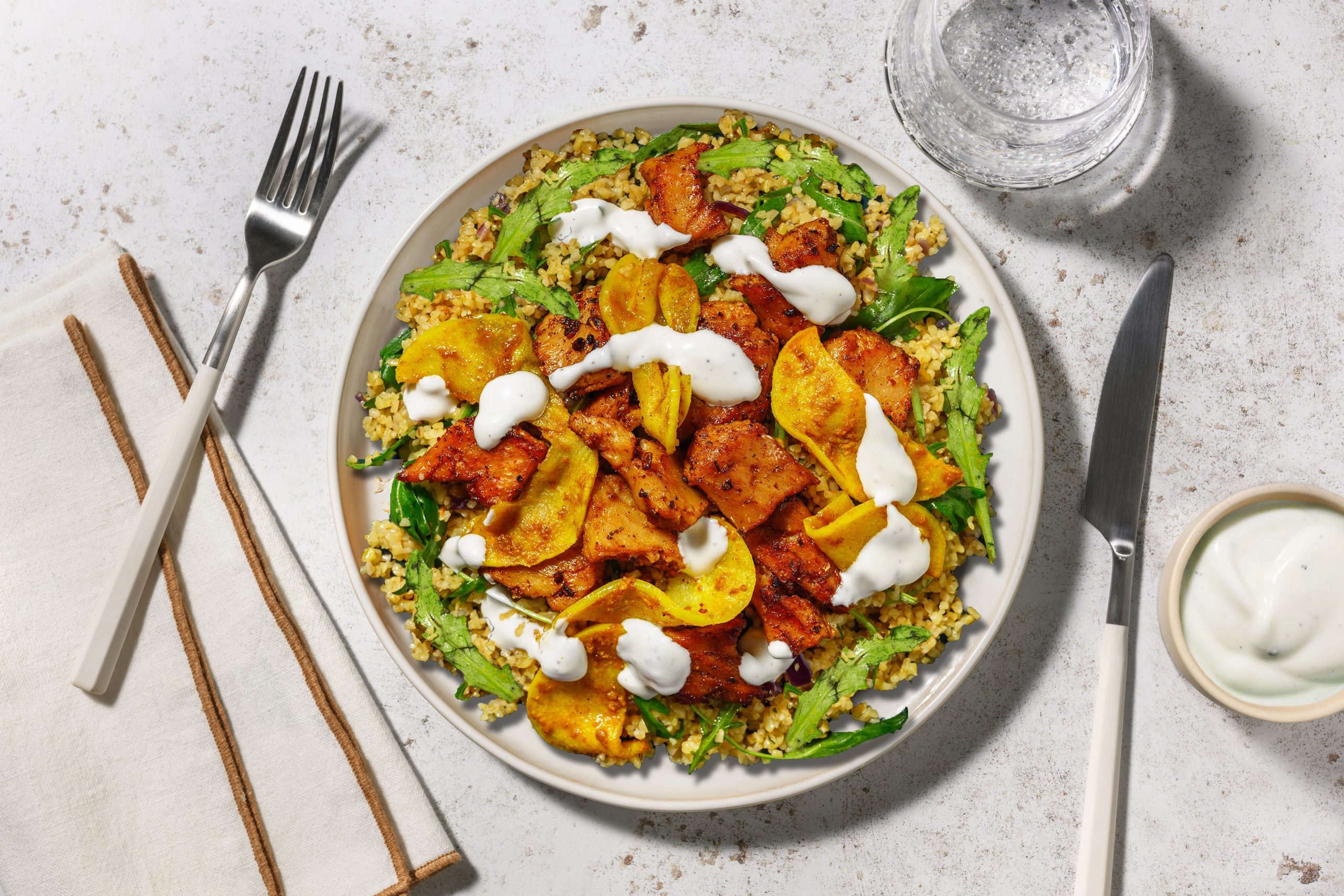 Heura con manzana a la curcuma con salsa de yogur sobre bulgur con rucula 1 scaled