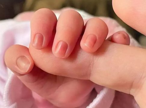 bebes calor Un bebé agarra un dedo de un adulto