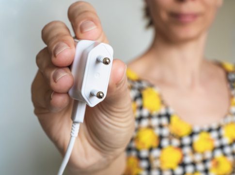 mano-de-mujer-sosteniendo-el-enchufe-electrico-de-cerca-la-hora-del-planeta-ahorra-energia-electrica