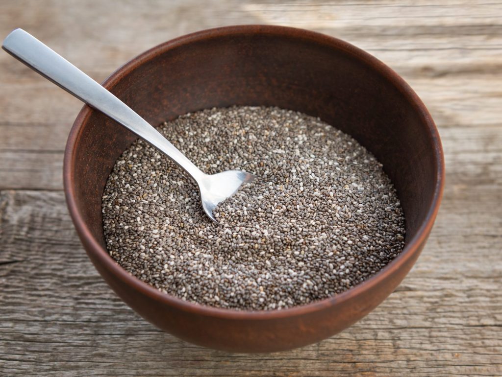 semillas de chia nutritivas en un recipiente sobre fondo de madera