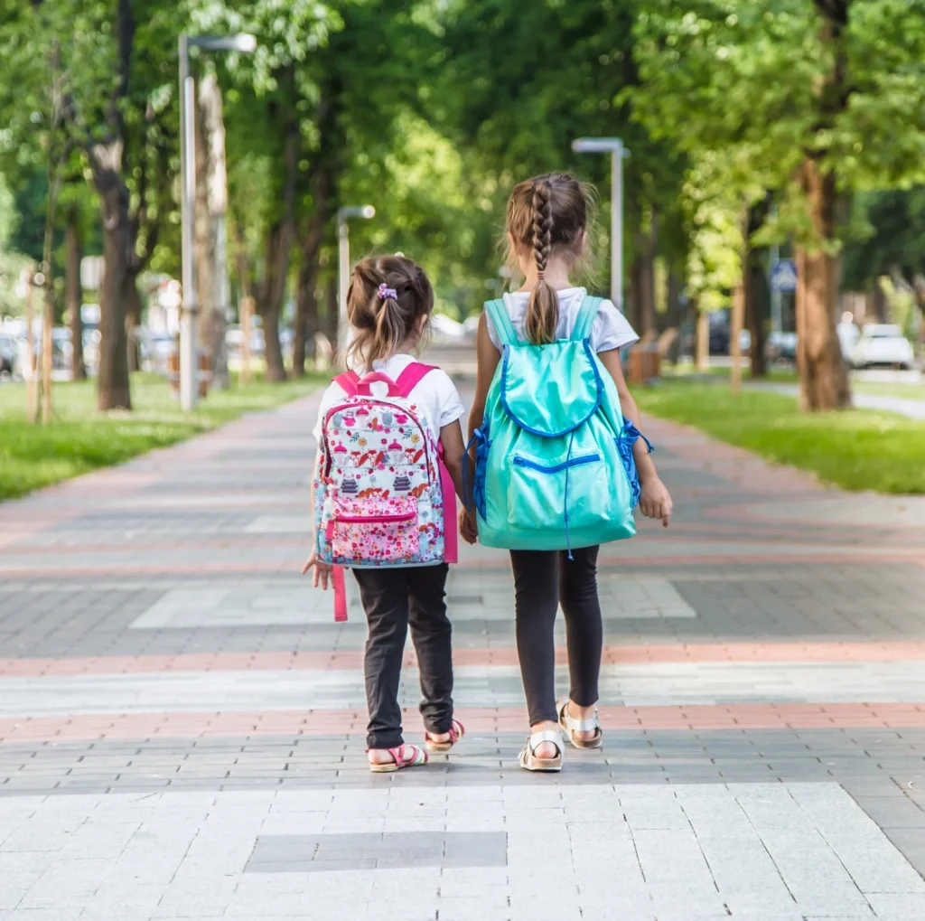 estudiantes de primaria que llevan mochilas para ir clase