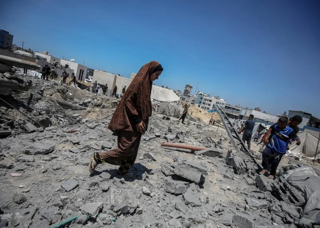 El terror en Gaza, narrado por dos trabajadores en pleno conflicto: «Así se siente la muerte» 2 Una mujer palestina camina por los escombros de Gaza