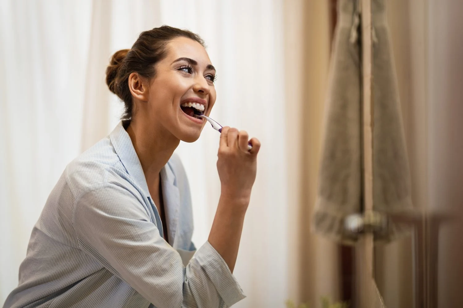 mujer-feliz-limpiandose-los-dientes-con-un-cepillo-de-dientes-por-la-manana
