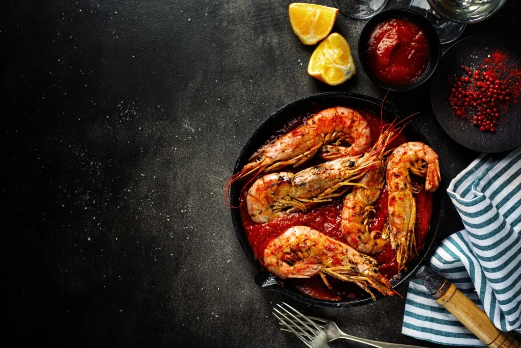 Justo al sacar las gambas de la plancha, llega el detalle que eleva el plato.  Fuente: Freepik 

