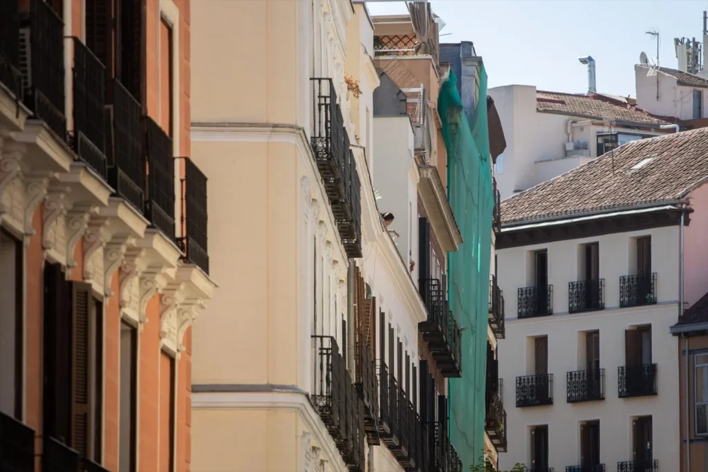 Una lona de obras en el edificio derrumbado de la calle Hileras de Madrid, en la zona de Ópera