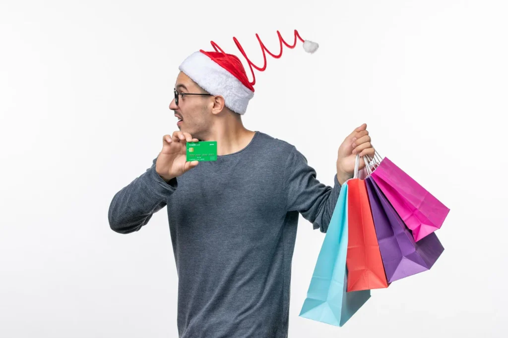 Una persona con la tarjeta de crédito y regalos navideños