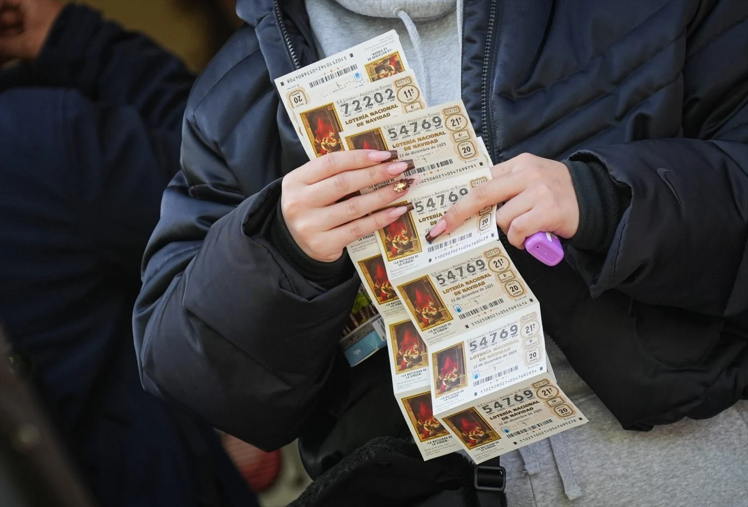 Una participante con varios décimos de Lotería de Navidad 2025
