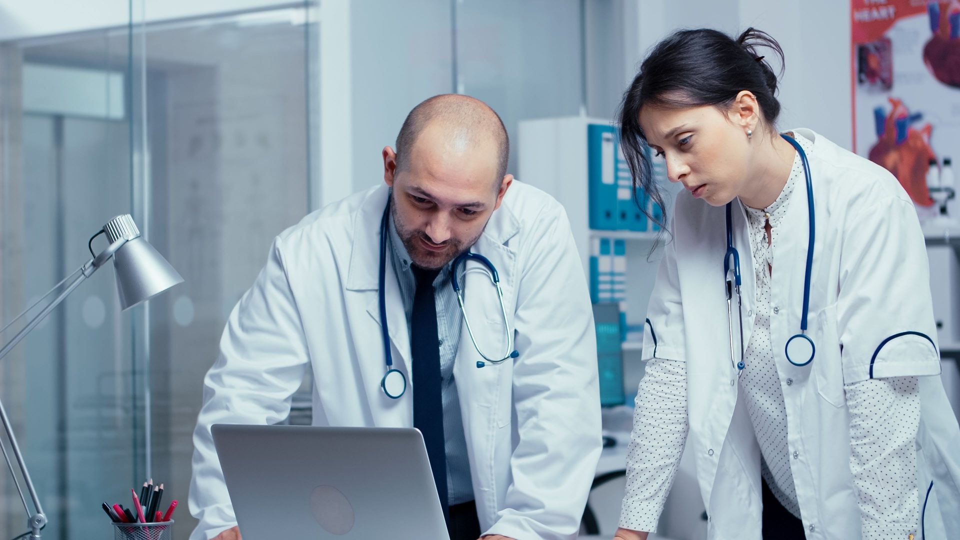 dos-colegas-medicos-discrepan-sobre-un-problema-medico-mientras-miran-la-computadora-portatil-y-hablan-de-ello-sistema-de-salud-clinica-hospitalaria-medica-moderna-privada