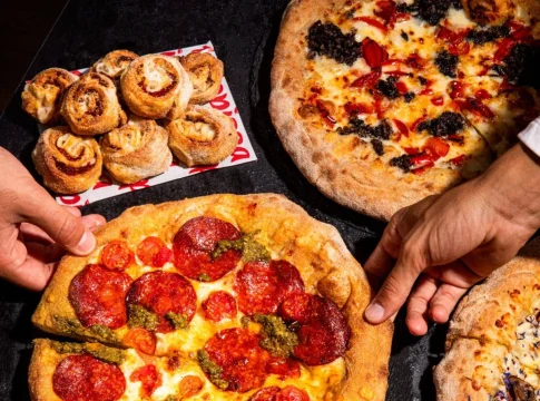 manos cogiendo una porcion de pizza Telepizza