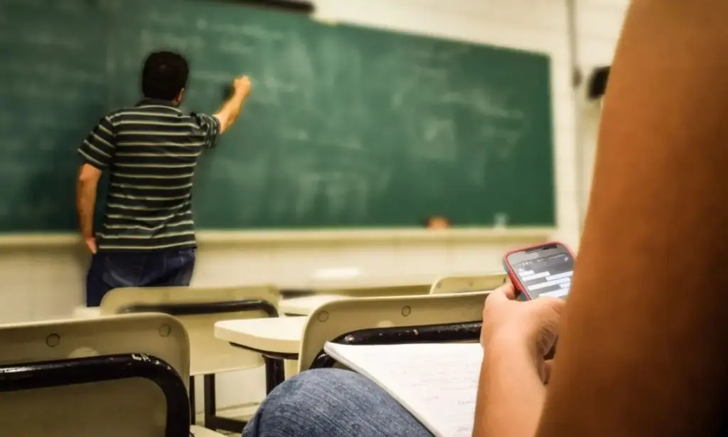 Solo 1 de cada 10 alumnos españoles son brillantes en Matemáticas, Lectura o Ciencias 1 Un alumno usa el móvil en clase mientras el profesor explica