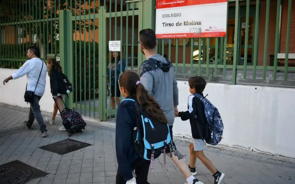 Un padre con sus hijos acudiendo a un colegio público de la Comunidad de Madrid