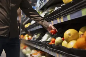 Persona comprando frutas y hortalizas en un supermercado