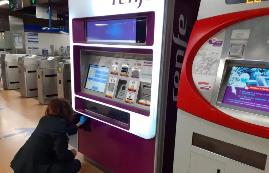 Una operadora de Renfe en las máquinas de venta de billetes de una estación