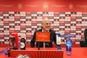 El seleccionador de España Luis de la Fuente con algunos patrocinadores de la selección de fondo, en 2025