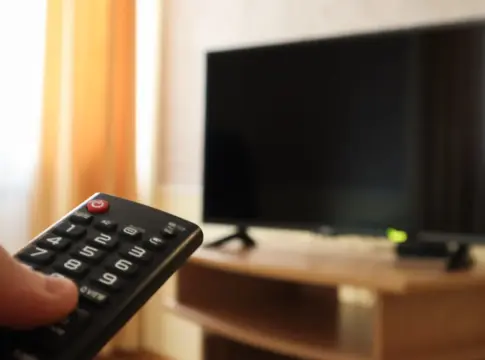 hand-holding-television-remote-control-surfing-programs-television-watch-turn-off-tv-living-room-bedroom-black-screen-nightstand-copy-space