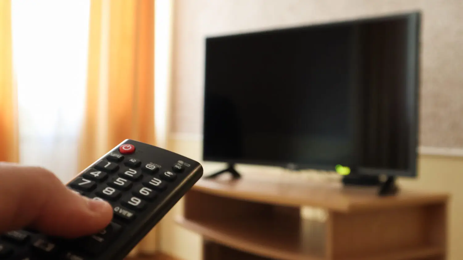 hand-holding-television-remote-control-surfing-programs-television-watch-turn-off-tv-living-room-bedroom-black-screen-nightstand-copy-space