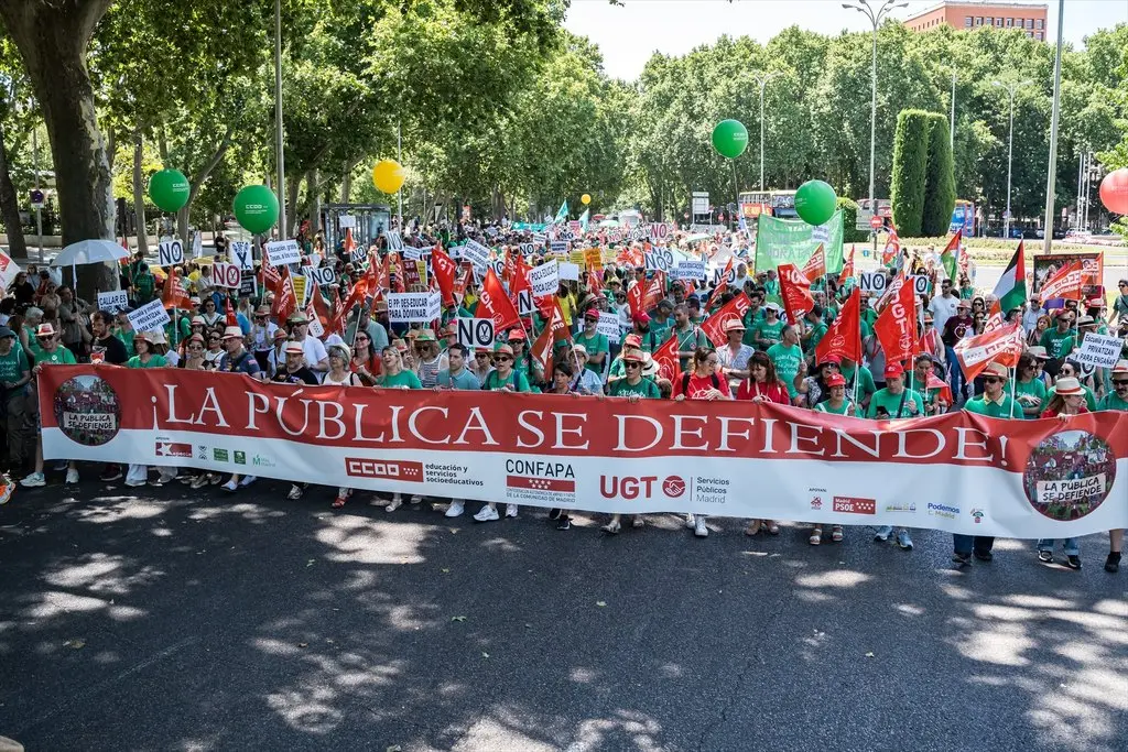Numerosas personas sostienen una pancarta con el lema '¡La pública se defiende!' durante una manifestación en favor de la educación pública, a 14 de junio de 2026, en Madrid