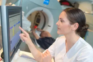 Una sanitaria realiza una resonancia magnética a un paciente | Foto de 123RF/auremar