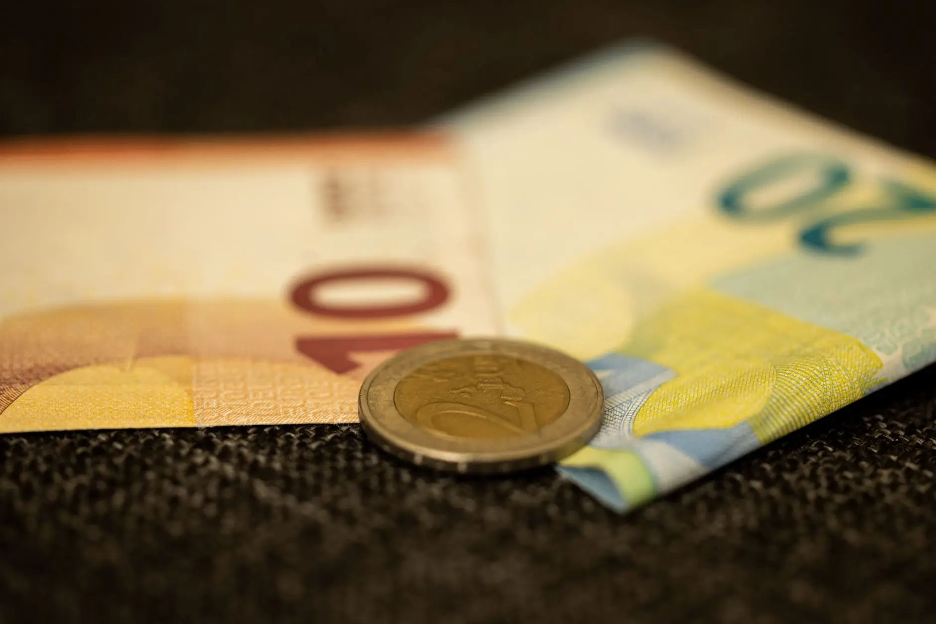 Primer plano detallado de billetes y monedas en Euros, mostrando la semejanza de la moneda europea.