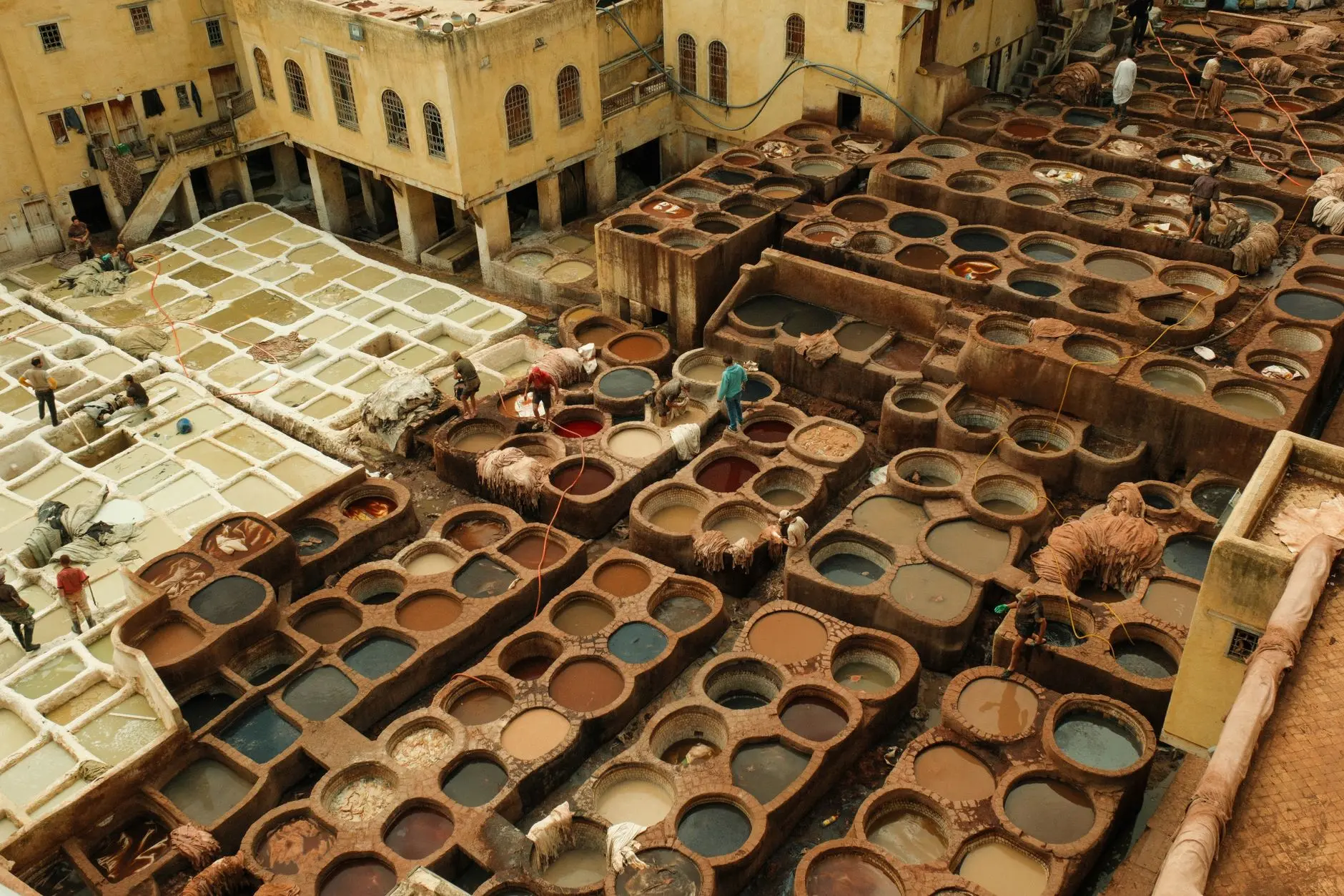 Vista aérea de la curtiduría tradicional de Fez, Marruecos, que muestra los coloridos pozos de tinte y a los trabajadores.