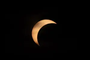 Una vista cautivadora de un eclipse solar parcial contra un cielo oscuro, que resalta la maravilla celestial.